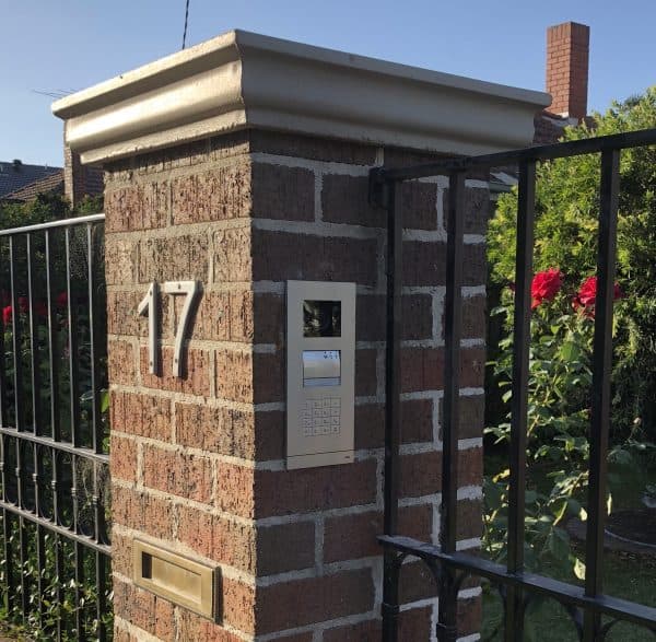 Photograph of a home access control system on a brick structure at a front gate numbered 17