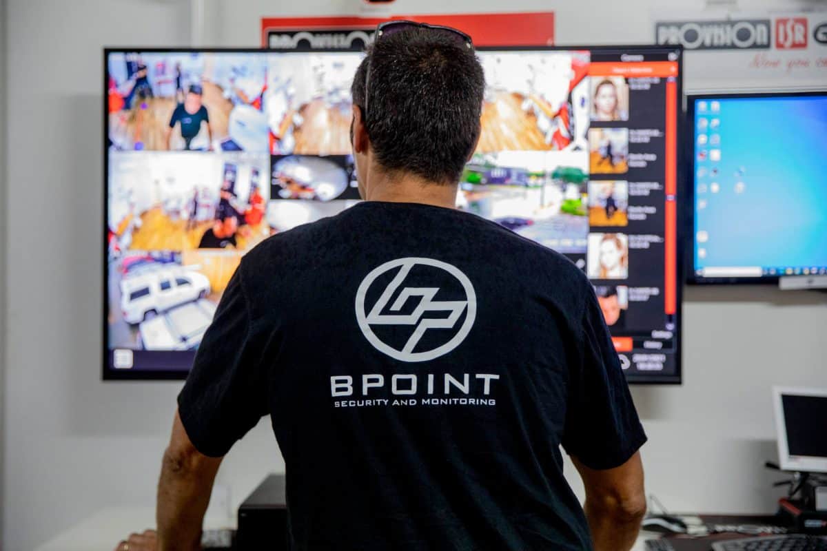 Bpoint technician reviewing live camera feeds on a video wall