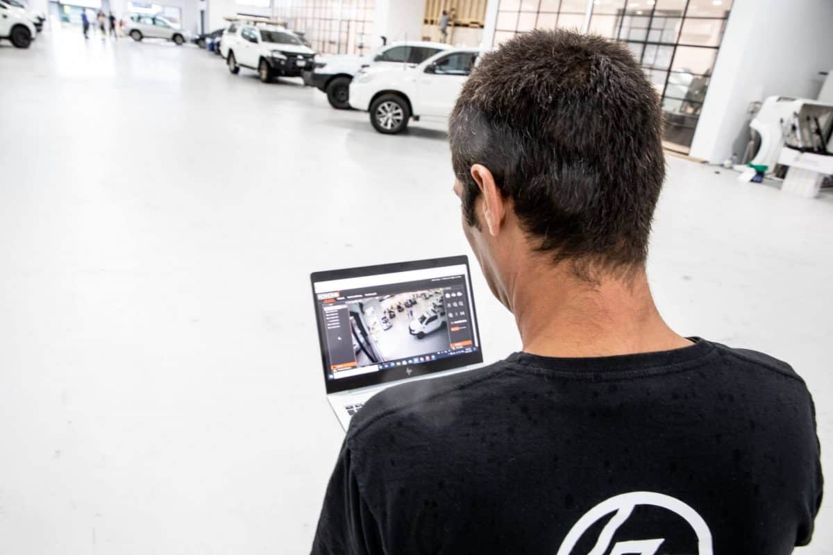 Bpoint technician reviewing a camera view on a laptop at a commercial site