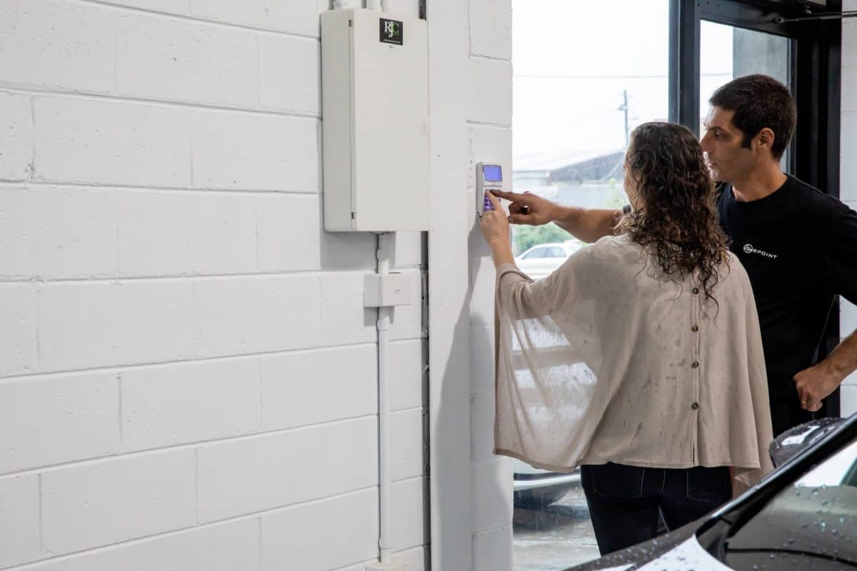 Bpoint technician showing a client a security keypad at a commercial entry